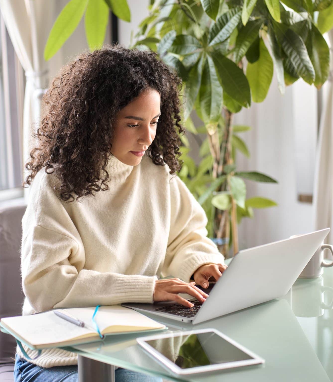 une femme concentrée utilisant un ordinateur portable pour suivre une formation en ligne de l'Ecole des TND