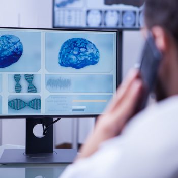 Doctor using smartphone to help a patient sitting in his office